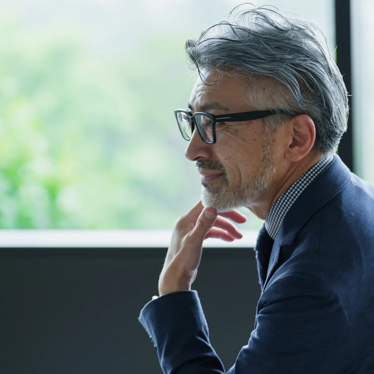 眼鏡をかけた男性がカメラに向かって微笑んでいる様子