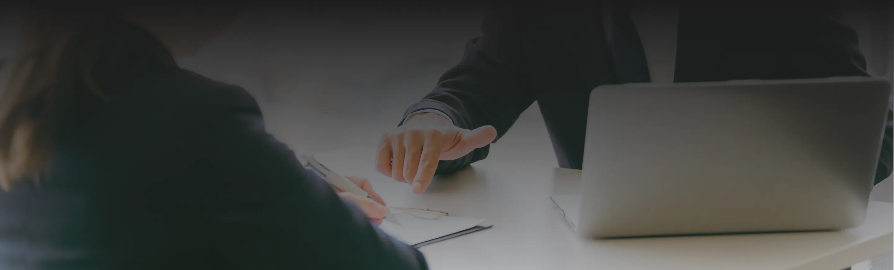 ビジネススーツを着た人々がテーブルを囲んで座っている様子