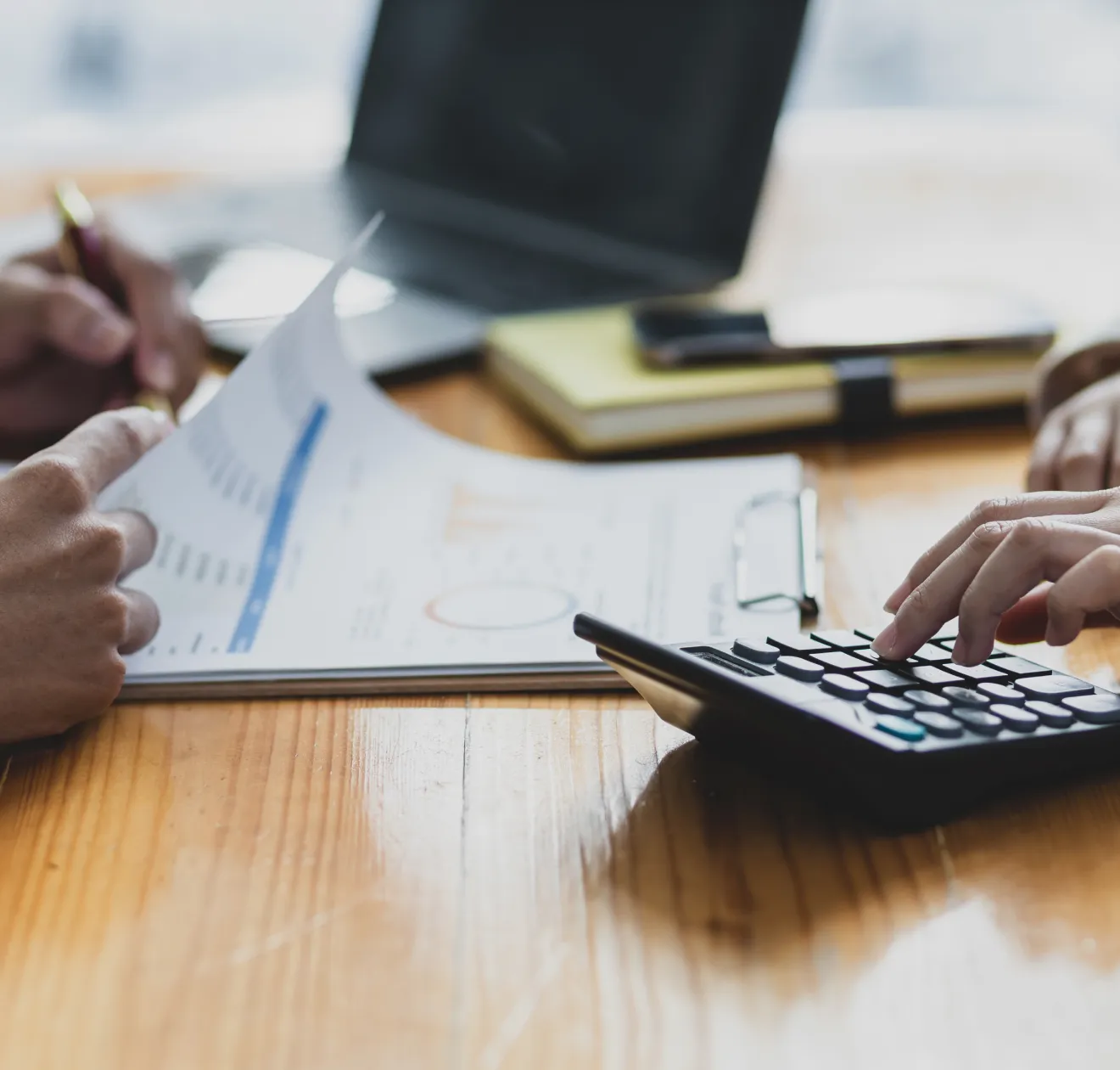 二人が計算機と書類を使って作業している様子