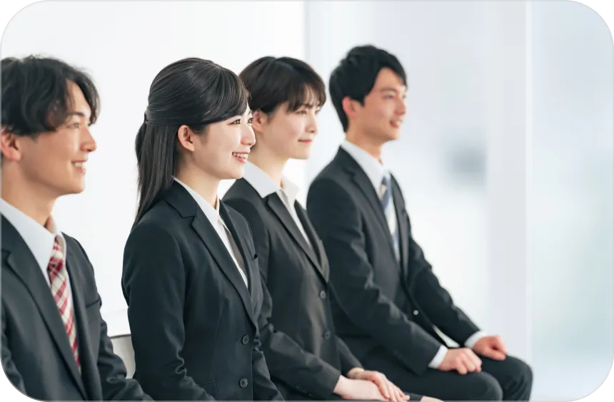 ビジネスパーソンのグループが一列に座っている様子