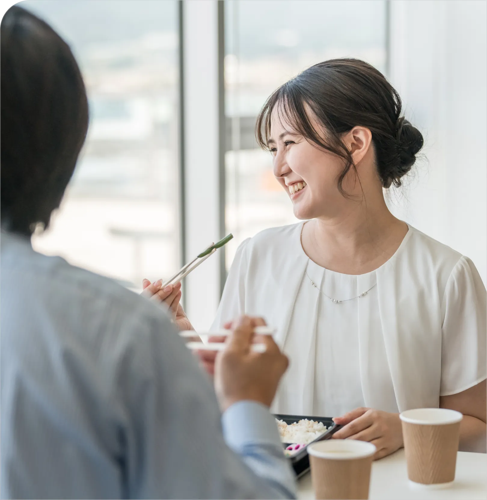 男性と一緒に食事を楽しむ女性の画像。笑顔で料理を味わっている様子